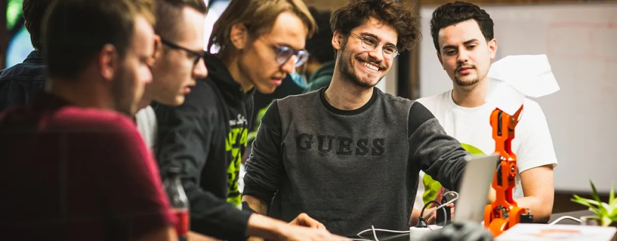 Studenten Internet of Things werken aan hun project en testen een robot uiit.