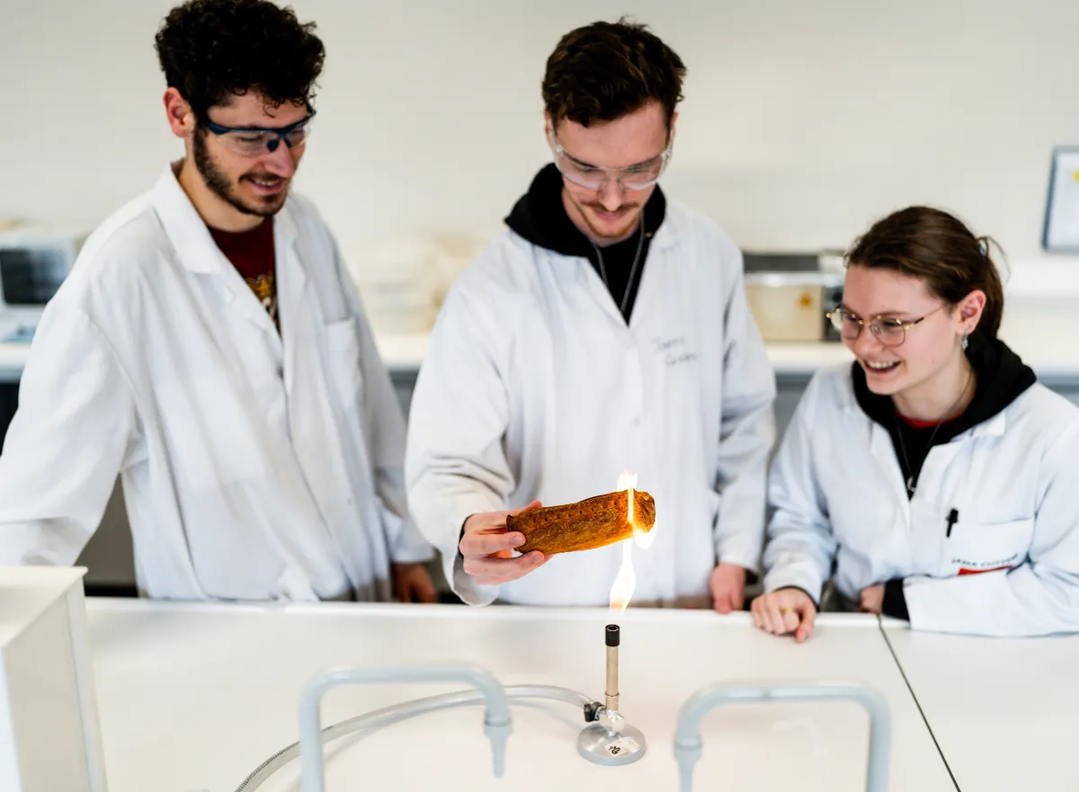 studenten testen worstenbrood bij brander
