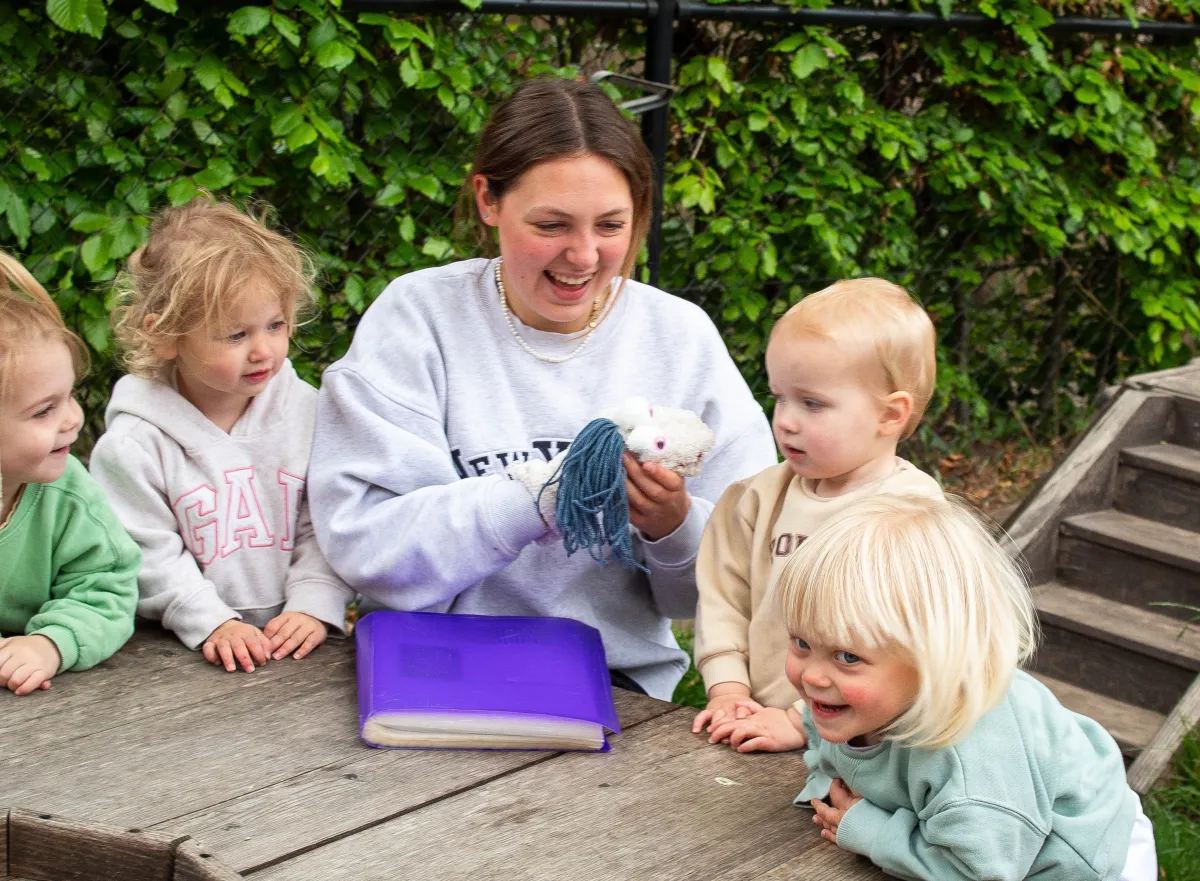 Kindernbegeleider entertaint peuters met een sokpop